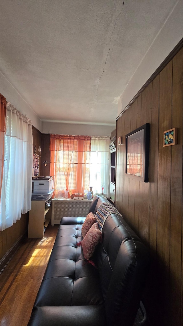 11419 179th St, Addisleigh Park, NY 11434 - living area featuring radiator heating unit, wooden walls, wood finished floors, and a textured ceiling
