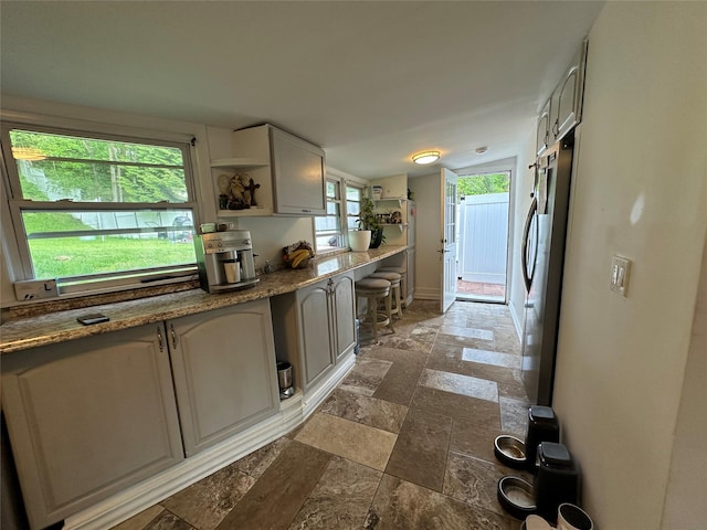 214SHOREDRIVE Shore Dr, Brewster, NY 10509 - kitchen featuring stone tile floors, freestanding refrigerator, baseboards, open shelves, and vaulted ceiling