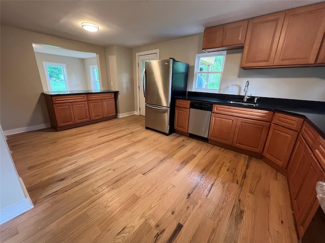692 Burlingham Rd, Bloomingburg, NY 12721 - kitchen featuring stainless steel appliances, a sink, light wood-style flooring, dark countertops, and baseboards