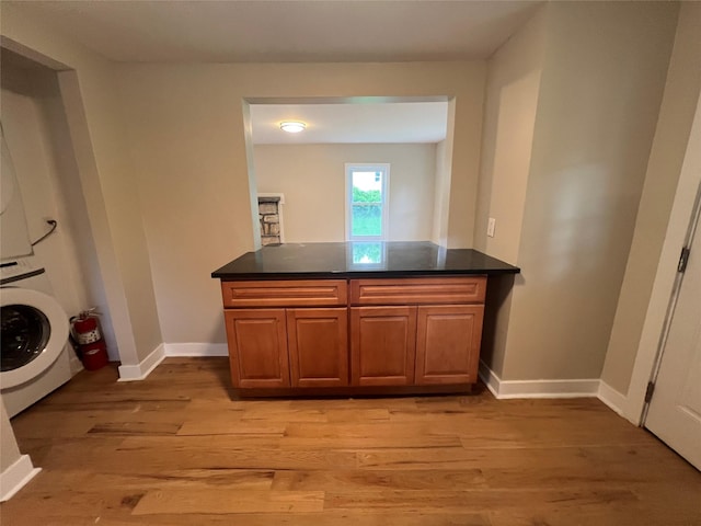 692 Burlingham Rd, Bloomingburg, NY 12721 - washroom featuring stacked washer / dryer, light wood-style flooring, baseboards, and cabinet space