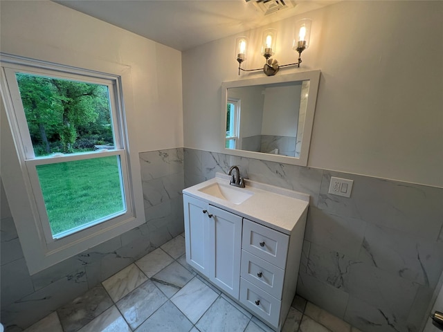 692 Burlingham Rd, Bloomingburg, NY 12721 - bathroom with tile walls, marble finish floors, healthy amount of natural light, vanity, and a wainscoted wall