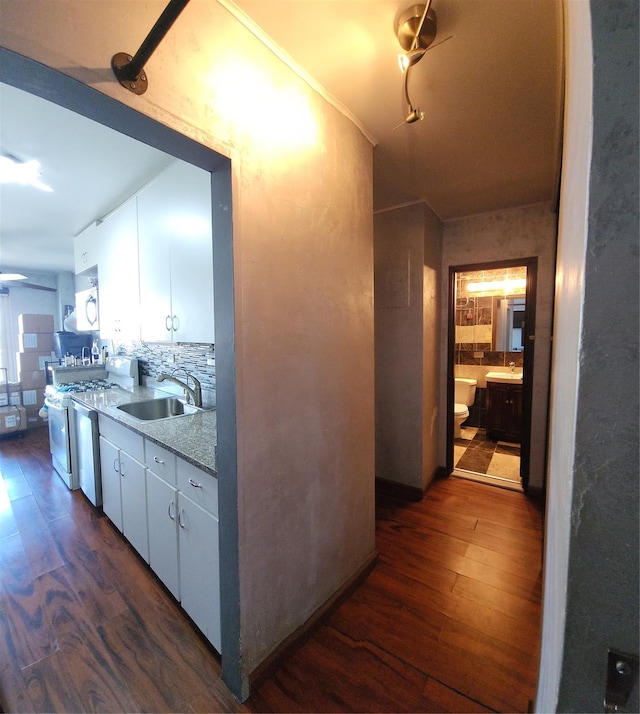 kitchen with a sink, white range with gas cooktop, dark wood-style floors, tasteful backsplash, and white cabinets