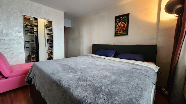 bedroom with wood finished floors and a closet