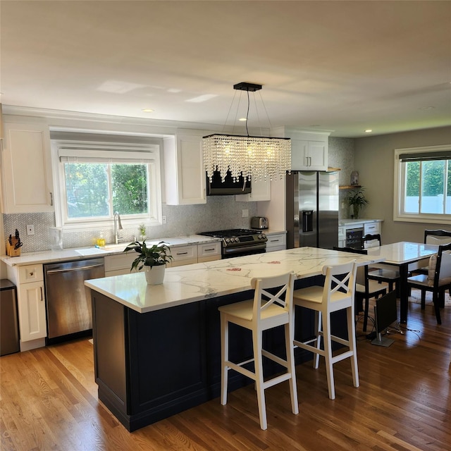 47 Barnum Ave, Plainview, NY 11803 - kitchen with appliances with stainless steel finishes, backsplash, a chandelier, light stone countertops, and recessed lighting