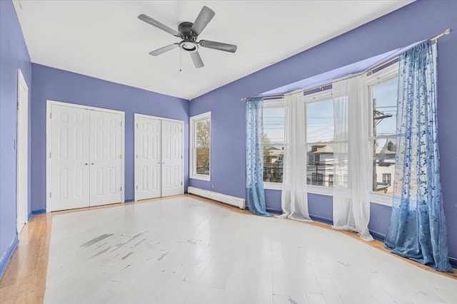 1465 Mayflower Ave, Bronx, NY 10461 - unfurnished bedroom with two closets, baseboard heating, wood finished floors, and multiple windows