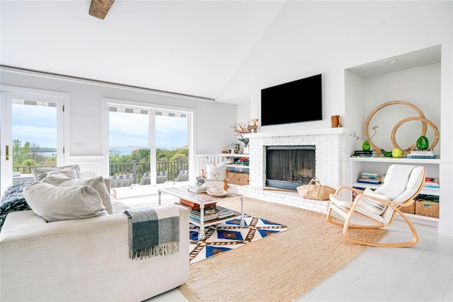 6 Beech Hollow Ct, Montauk, NY 11954 - living area with healthy amount of natural light, a brick fireplace, and high vaulted ceiling