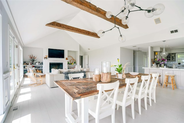 6 Beech Hollow Ct, Montauk, NY 11954 - dining area featuring beamed ceiling, high vaulted ceiling, and a fireplace