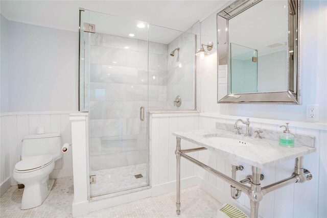6 Beech Hollow Ct, Montauk, NY 11954 - full bathroom with a sink, toilet, a stall shower, a wainscoted wall, and tile patterned floors