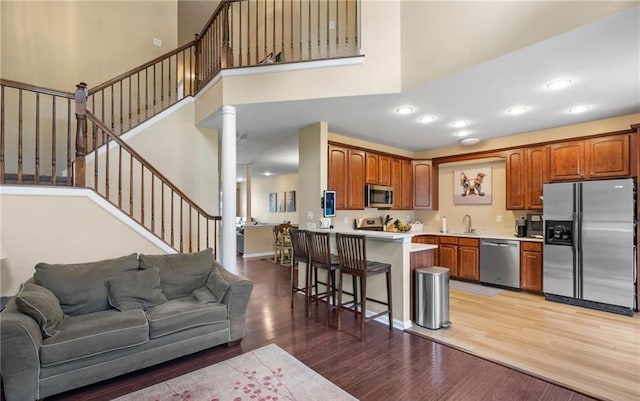 5 Case Ct, Monroe, NY 10950 - living room with ornate columns, light wood-style flooring, stairway, a towering ceiling, and recessed lighting