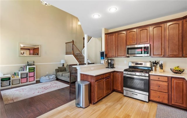 5 Case Ct, Monroe, NY 10950 - kitchen featuring stainless steel appliances, a peninsula, light wood-type flooring, and light countertops