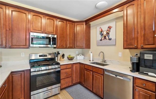 5 Case Ct, Monroe, NY 10950 - kitchen featuring stainless steel appliances, a sink, brown cabinetry, and light stone countertops