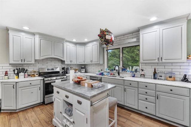 150 Cedar Ave, Poughkeepsie, NY 12603 - kitchen featuring appliances with stainless steel finishes, a sink, backsplash, light wood-type flooring, and light countertops