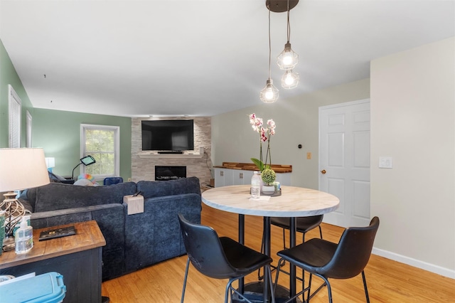150 Cedar Ave, Poughkeepsie, NY 12603 - dining room with a large fireplace, light wood-type flooring, and baseboards