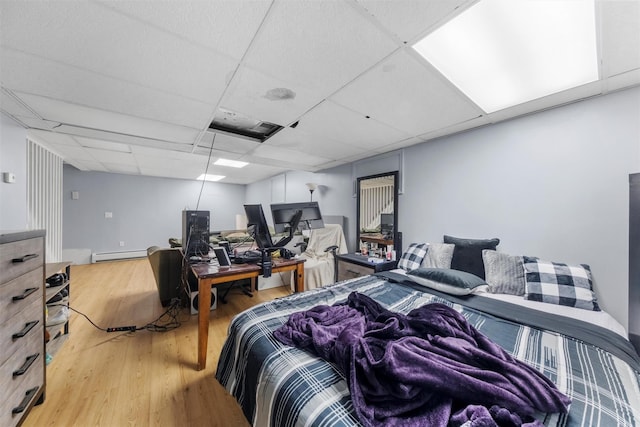 150 Cedar Ave, Poughkeepsie, NY 12603 - bedroom with a drop ceiling, a desk, wood finished floors, and a baseboard heating unit