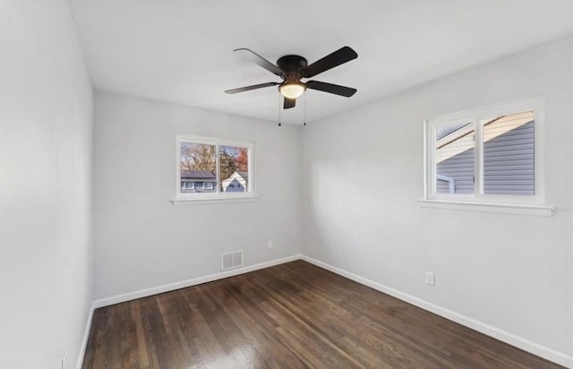 unfurnished room featuring baseboards, dark wood-type flooring, and a ceiling fan