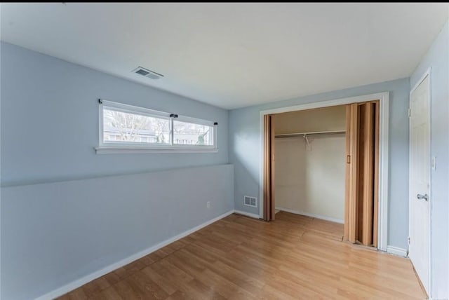unfurnished bedroom with light wood finished floors, a closet, and baseboards