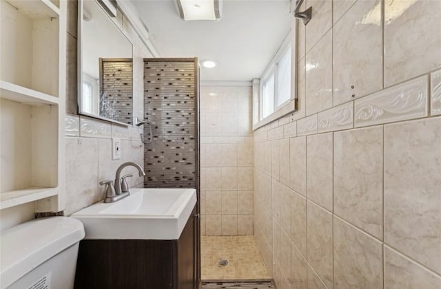 bathroom featuring tiled shower, vanity, tile walls, toilet, and recessed lighting