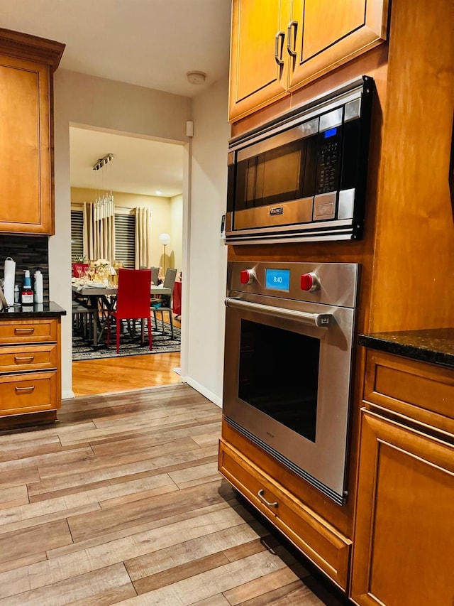 9 Hill And Tree Ct, Melville, NY 11747 - kitchen featuring appliances with stainless steel finishes, brown cabinets, and light wood-style flooring