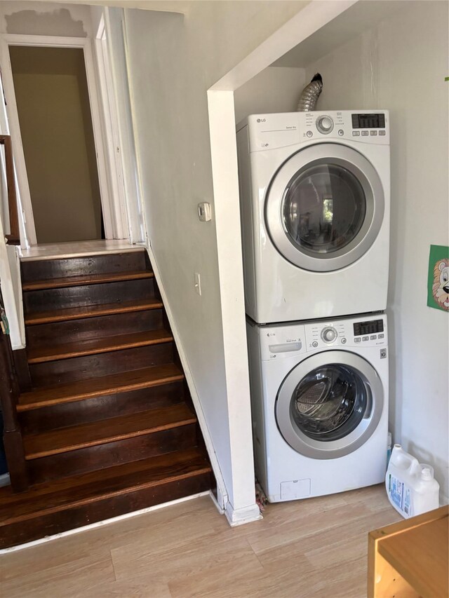 109 Convent Rd, Syosset, NY 11791 - laundry area with stacked washing machine and dryer and wood finished floors
