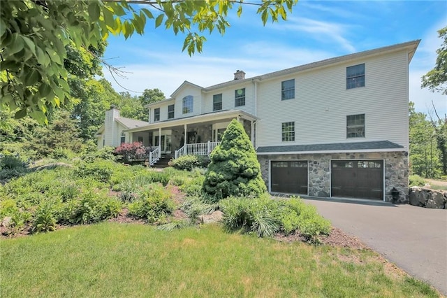 225 Berry Rd, Monroe, NY 10950 - view of front of house featuring an attached garage, driveway, a chimney, stone siding, and covered porch