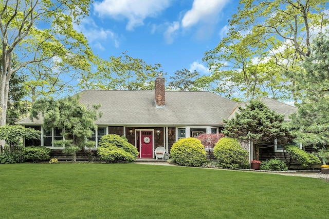 cape cod house with a front yard, a chimney, and a shingled roof