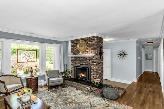 living room featuring wood finished floors, a brick fireplace, crown molding, and baseboards