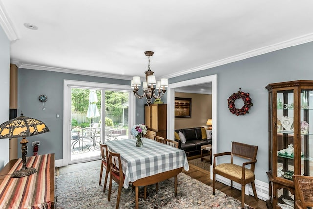 dining room featuring a chandelier, crown molding, baseboards, and wood finished floors