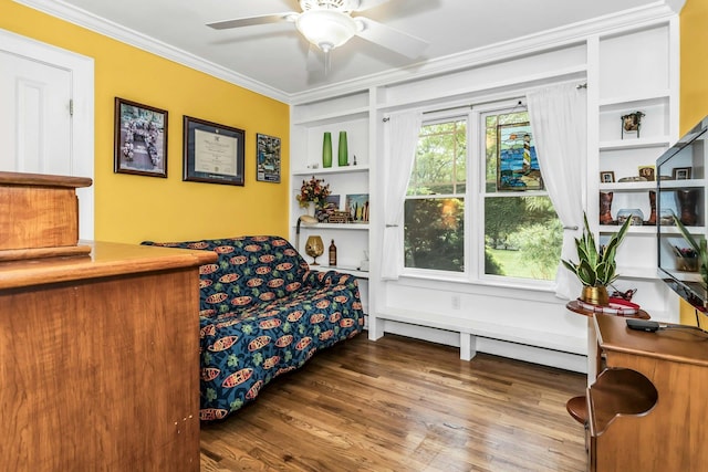 sitting room featuring crown molding, wood finished floors, ceiling fan, and built in shelves