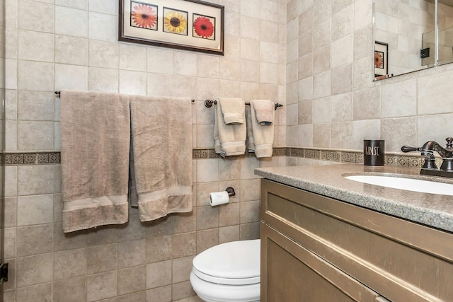 bathroom featuring tile walls, toilet, and vanity