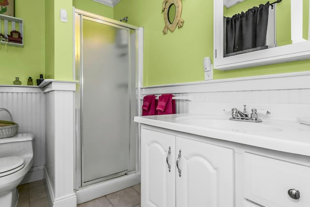 bathroom featuring tile patterned floors, a stall shower, toilet, and vanity