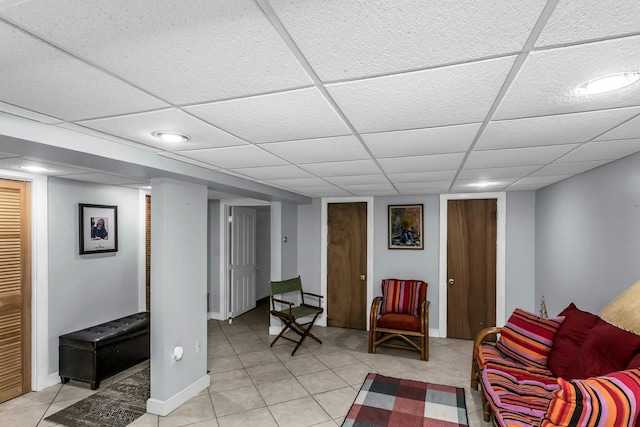 living area featuring light tile patterned floors and a paneled ceiling