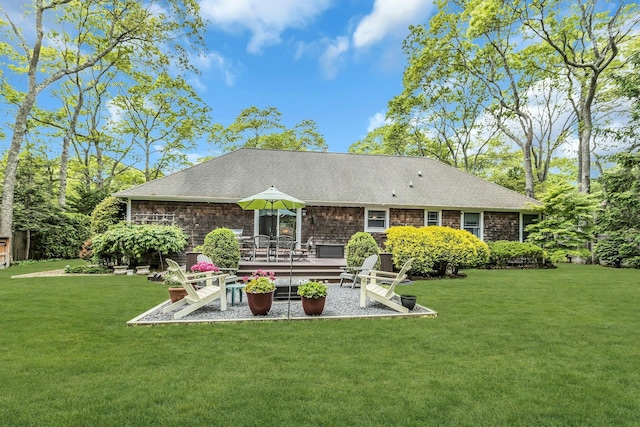 back of house featuring a yard and a shingled roof