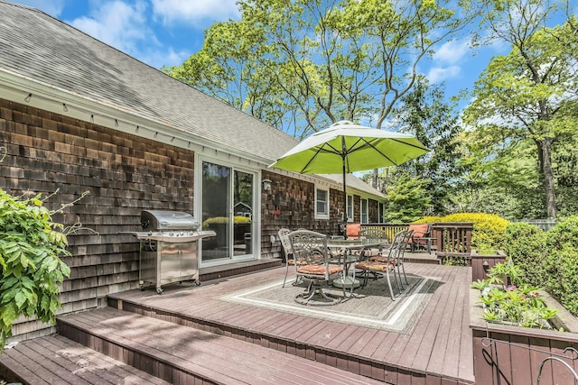 wooden terrace with grilling area and outdoor dining space