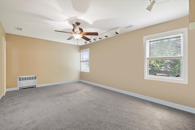 525 Green Pl, Woodmere, NY 11598 - unfurnished room featuring radiator heating unit, rail lighting, carpet floors, a ceiling fan, and baseboards