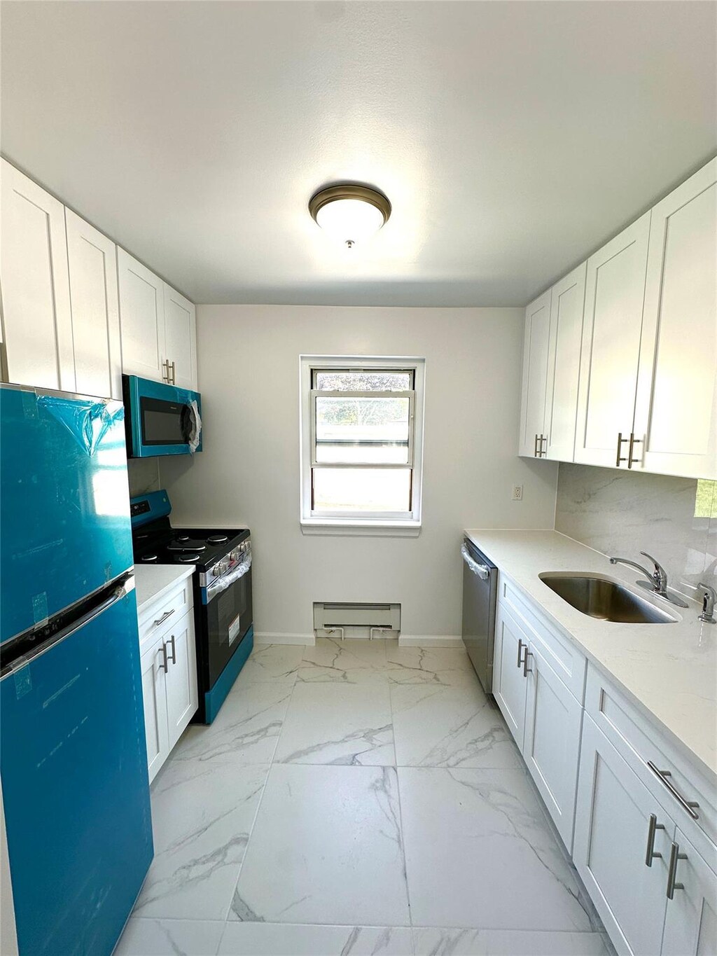 68-14 150th St Unit 463B, Flushing, NY 11367 - kitchen featuring gas range, a sink, freestanding refrigerator, dishwasher, and baseboards