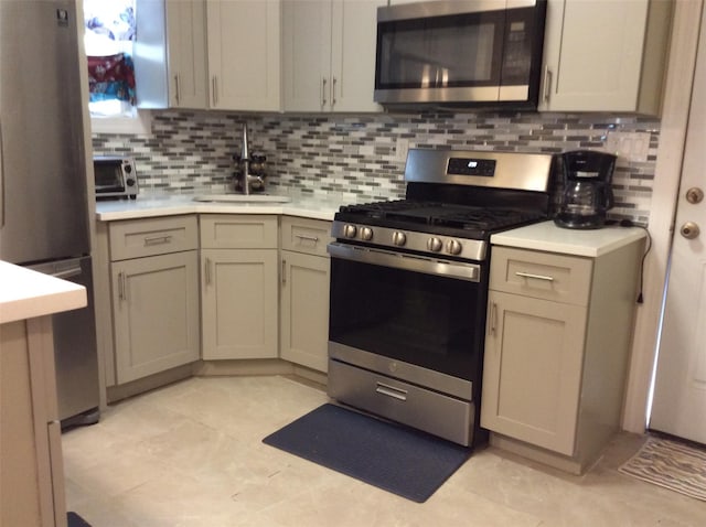 114-30 158th St, Jamaica, NY 11434 - kitchen with appliances with stainless steel finishes, a sink, light countertops, tasteful backsplash, and light tile patterned flooring
