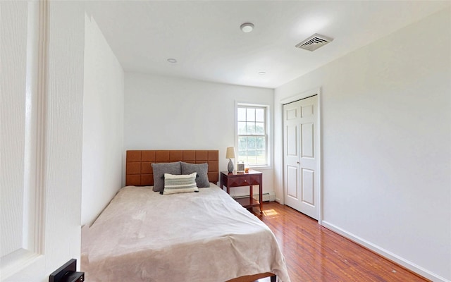395 Toleman Rd, Washingtonville, NY 12575 - bedroom featuring wood finished floors, baseboard heating, a closet, and baseboards