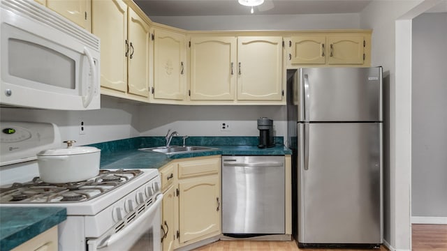 109 Doxbury Ln, Suffern, NY 10901 - kitchen featuring stainless steel appliances, a sink, dark countertops, cream cabinets, and light wood-style floors