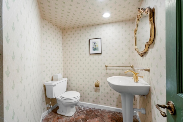 66 Susan Dr, Newburgh, NY 12550 - half bathroom with baseboards, toilet, brick floors, and a sink