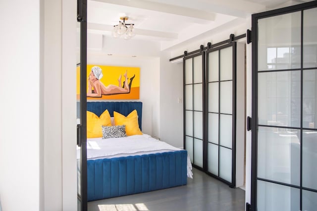 bedroom featuring beam ceiling, a barn door, a chandelier, and wood finished floors