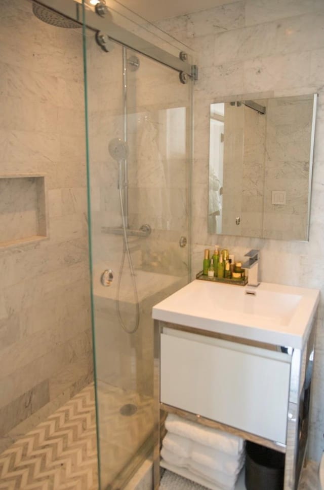 bathroom featuring tile walls, a shower stall, and vanity