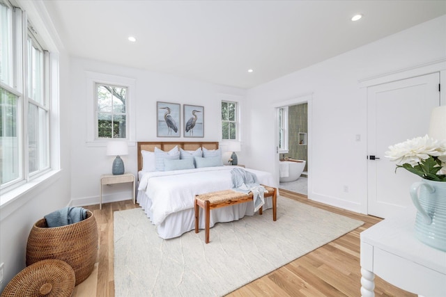 480 Ackerly Pond Ln, Southold, NY 11971 - bedroom featuring multiple windows, light wood-style floors, recessed lighting, baseboards, and ensuite bathroom
