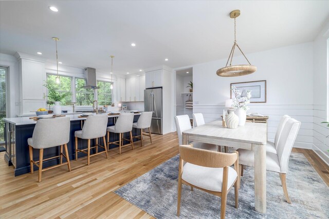 480 Ackerly Pond Ln, Southold, NY 11971 - dining room featuring light wood finished floors, recessed lighting, a wainscoted wall, and a decorative wall