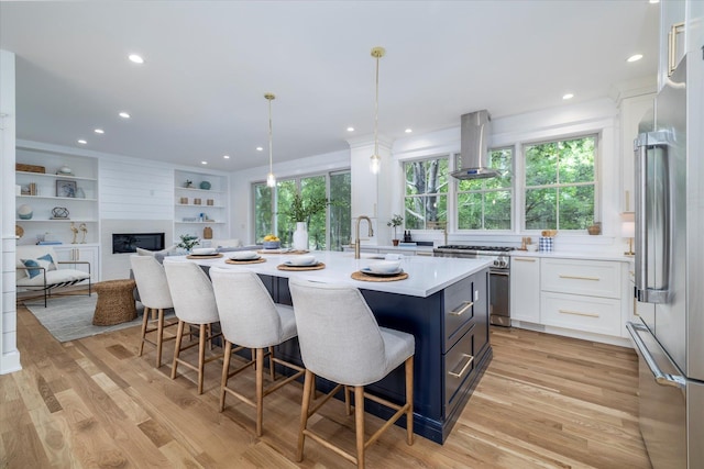 480 Ackerly Pond Ln, Southold, NY 11971 - kitchen featuring high end appliances, island range hood, white cabinetry, light countertops, and a kitchen breakfast bar