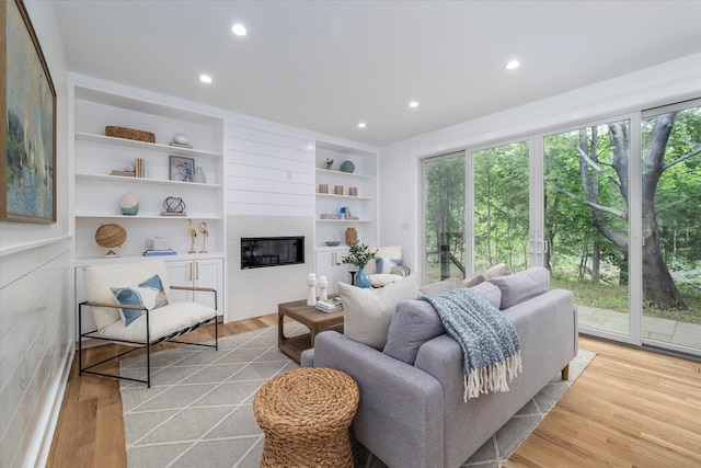 480 Ackerly Pond Ln, Southold, NY 11971 - living area with a large fireplace, light wood-style flooring, recessed lighting, and built in shelves