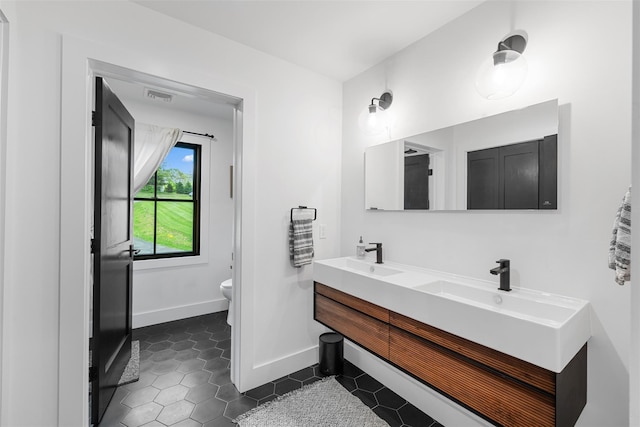 36 Spruce Ln, Poughkeepsie, NY 12603 - full bath featuring toilet, tile patterned floors, double vanity, and baseboards