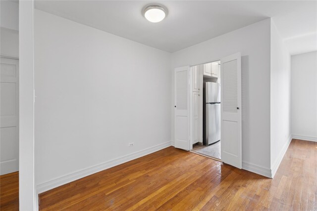 100-11 67th Rd Unit 416, Forest Hills, NY 11375 - unfurnished bedroom with freestanding refrigerator, light wood-style flooring, baseboards, and a closet