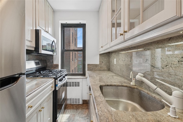 100-11 67th Rd Unit 416, Forest Hills, NY 11375 - kitchen with stainless steel appliances, a sink, radiator, and tasteful backsplash