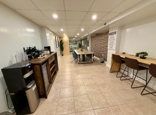 210 Pelham Rd Unit 6H, New Rochelle, NY 10805 - interior space with light tile patterned flooring, brick wall, a drop ceiling, recessed lighting, and baseboards