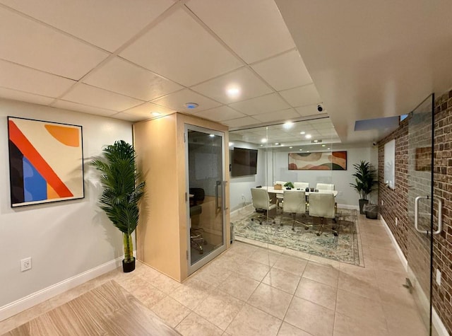 210 Pelham Rd Unit 6H, New Rochelle, NY 10805 - full bathroom featuring brick wall, baseboards, a drop ceiling, tile patterned floors, and a stall shower